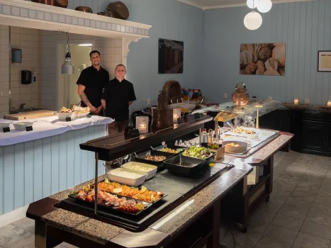 To kokker står ved siden av hverandre ved sommerbuffeten