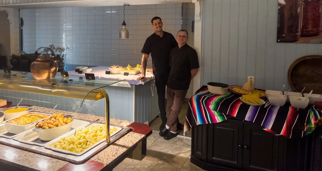 To kokker står ved soden av sommerbuffeten