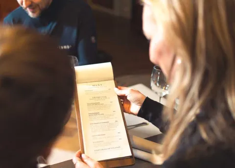 Dame viser meny til et barn