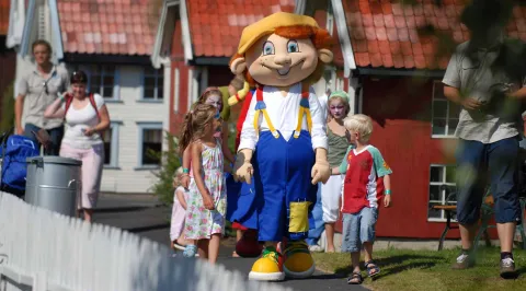 Maskot Ola med 4 barn rundt seg