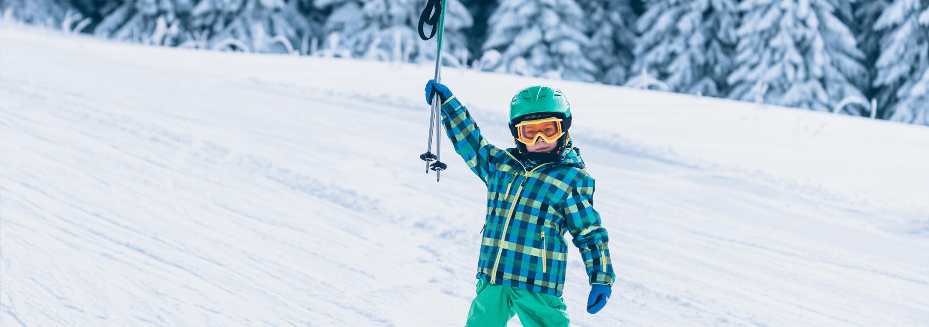 Barn på ski med stavene i været